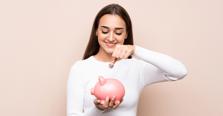 Mujer adulta introduciendo una moneda en una alcancía