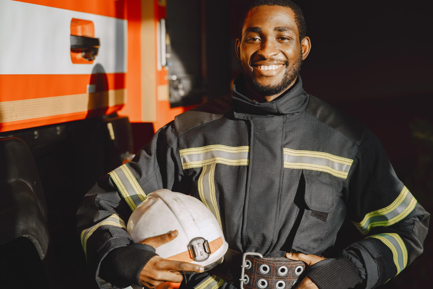 Bombero sonriente con su casco en la mano