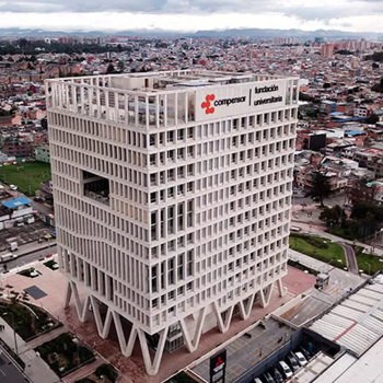 Edificio sede de la universidad Compensar de color blanco, ventanales en cristal, rodeado de un barrio.