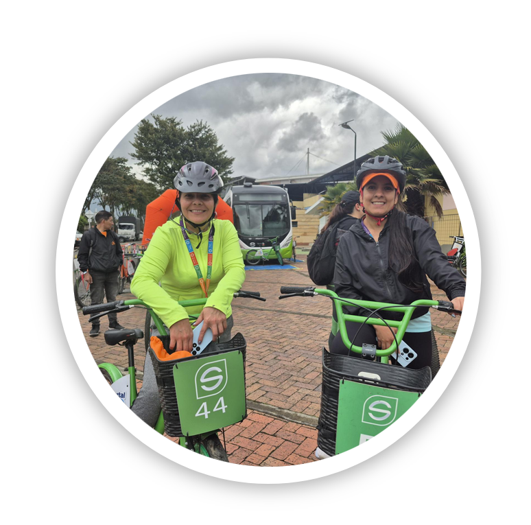 Imagen de mujeres en bicicleta con bus de fondo