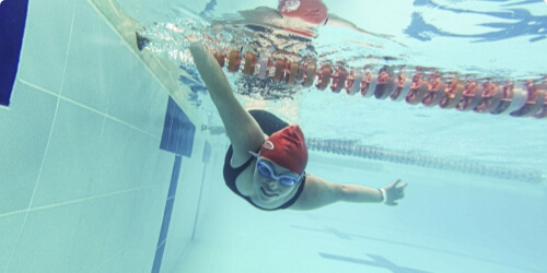mujer nadando en lo profundo de una piscina olimpica