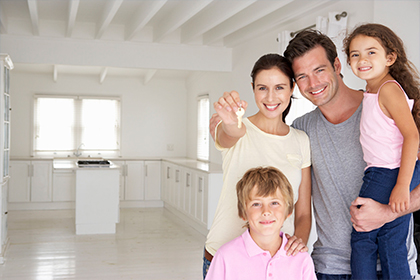 Familia sonriendo en la sala de su nueva casa, crédito para compra de vivienda Compensar