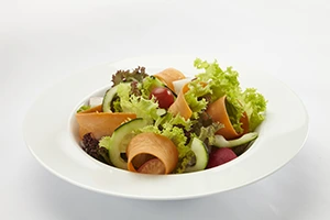 Plato vegetariano preparado con lechuga, tomate cherry, crocantes y rodajas de aguacate