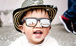 Niño con sombrero típico de la región Caribe y gafas de sol sonríe