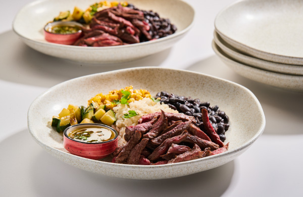 Bowl con carne de res, verduras, arroz, fríjoles negros y maíz.