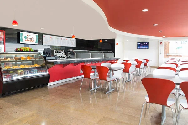 Modernas instalaciones con mesas y barra del restaurante autoservicio de la sede Calle 220