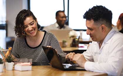 imagen de personas sonriendo trabajando en un coworking 