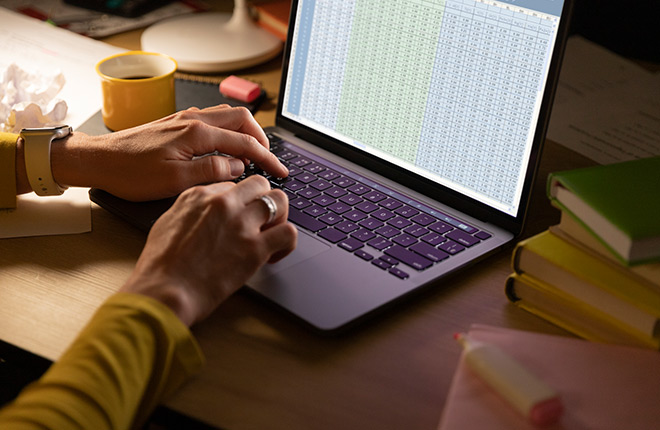Usuario digitanto en una tabla de excel desde su portátil