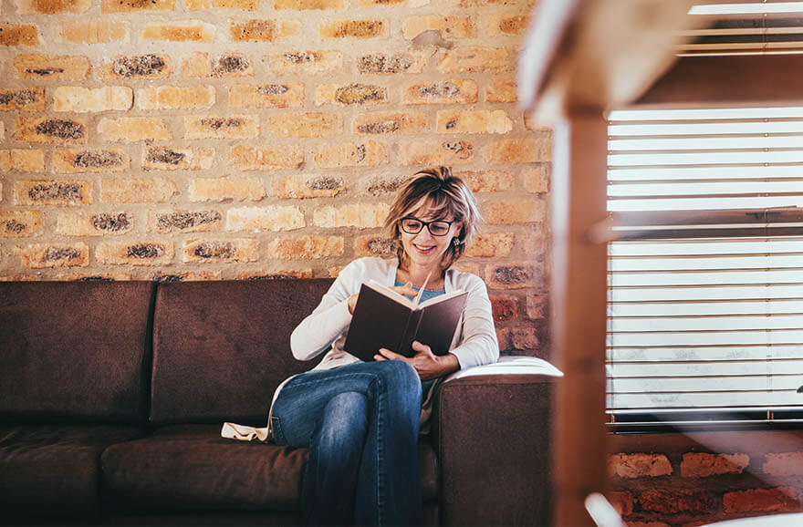 Mujer leyendo un libro en un sillón