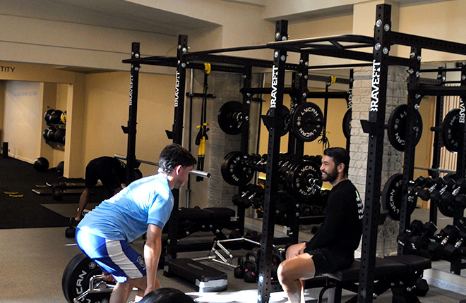 Hombres entrenando con pesas en el gimnasio