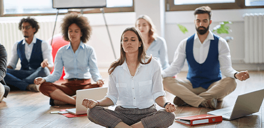 Grupo de colaboradores participando en actividad de bienestar como Yoga.