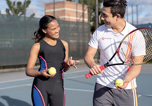 instructor dando clases a una mujer sobre tennis