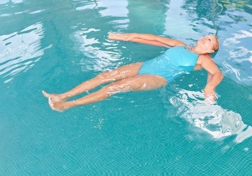 mujer realizando yoga en la piscina