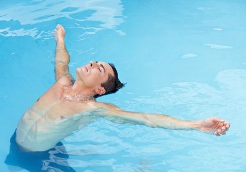 hombre realizando yoga en una piscina