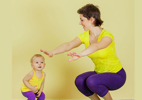 mujer acompañada de una niña realizando ejercicios de equilibrio
