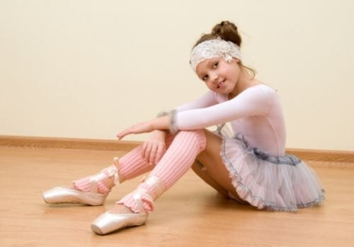 niña con traje de ballet sentada