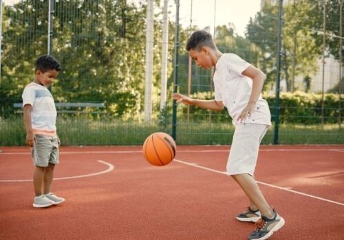 niños jugando baloncesto en una cancha
