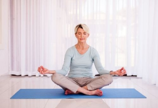 mujer adulta haciendo pose de yoga en la sala 