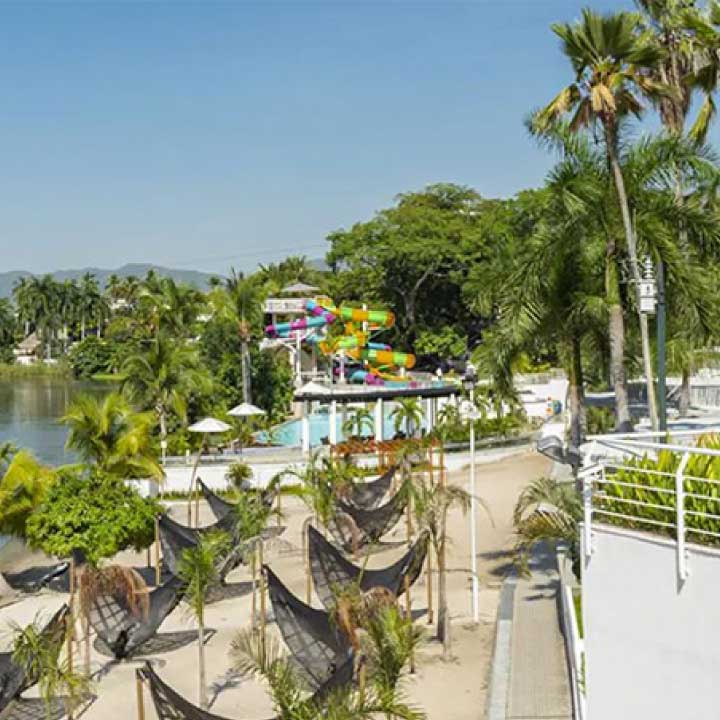 Espacio turístico con palmeras, zonas verdes y senderos, representando locaciones en diferentes partes del mundo. 
