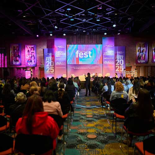 Auditorio empresarial con escenario iluminado y público en un evento