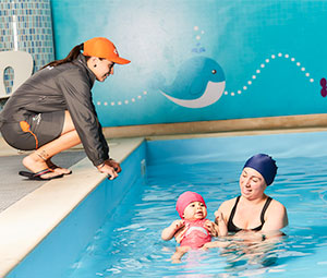 Imagen de una señora y su bebé en una piscina de Compensar