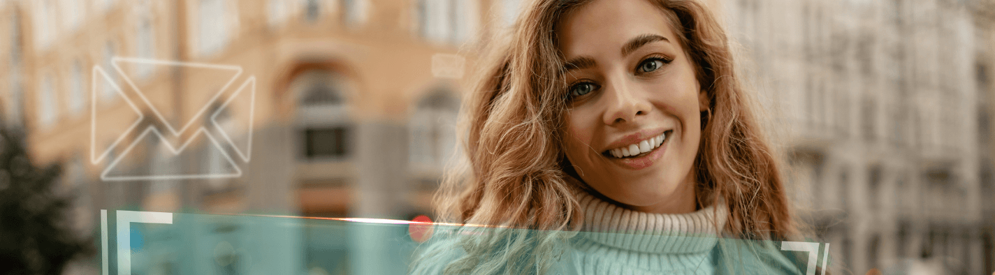 imagen de una mujer joven sonriendo mirando al frente sosteniendo en sus manos un celular y café