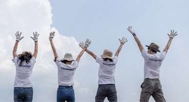 jÃ³venes de espalda con sus brazos levantados hacia el cielo.Â 