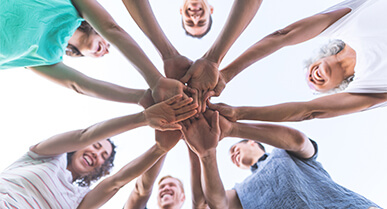 grupo de jÃ³venes mirÃ¡ndose entre sÃ­ con sus manos extendidas hacia el frente.Â 