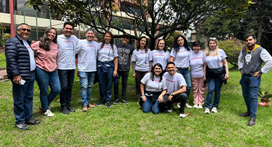 rupo de colaboradores unidos sonriendo y mirando hacia el frente.Â 