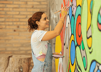 imagen de una mujer pintando un mural