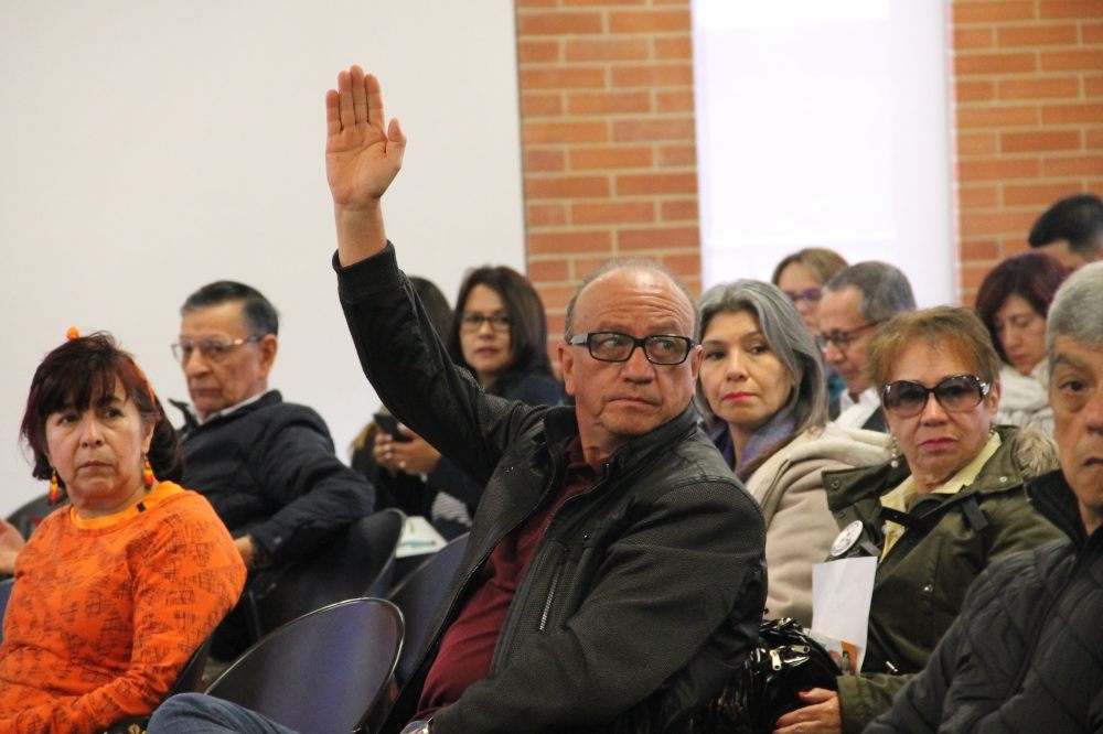 señor de edad levantando la mano para decir una opinion