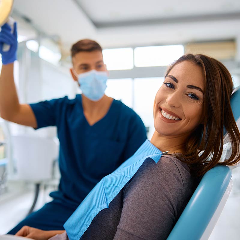 Mujer sonriendo junto a odontológo